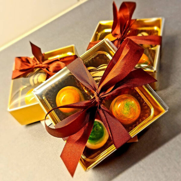 4 Cavity Bright Gold Base with Clear Lid & Orange Ribbon. Chocolate Truffles